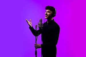 dekoratyvinis paveikslėlis, dainuojantis jaunuolis su mikrofonu