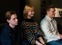 three people sitting and smiling