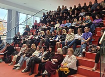 Konferencijos dalyviai sėdi amfiteatre