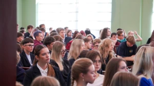 Daug vaikų sėdi konferencijoje